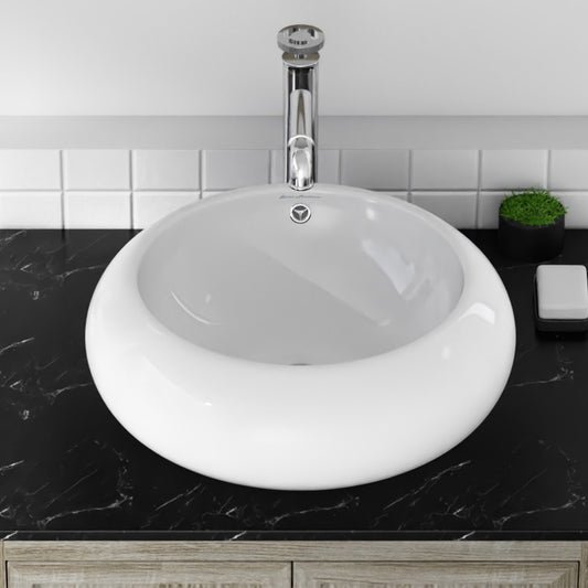 Round vessel sink in glossy white ceramic with chrome faucet and black countertop.
