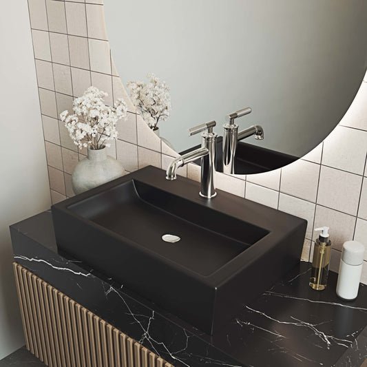 Rectangular matte black ceramic vessel sink with flat bottom and centered drain hole.