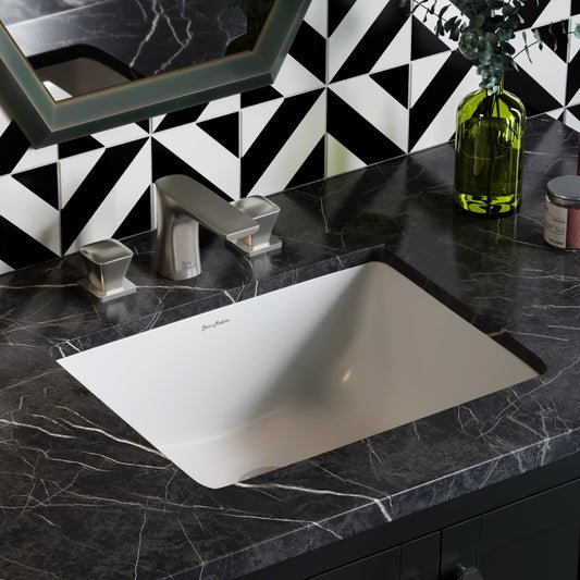 Rectangular undermount bathroom sink in white with black marble countertop and chrome faucet.