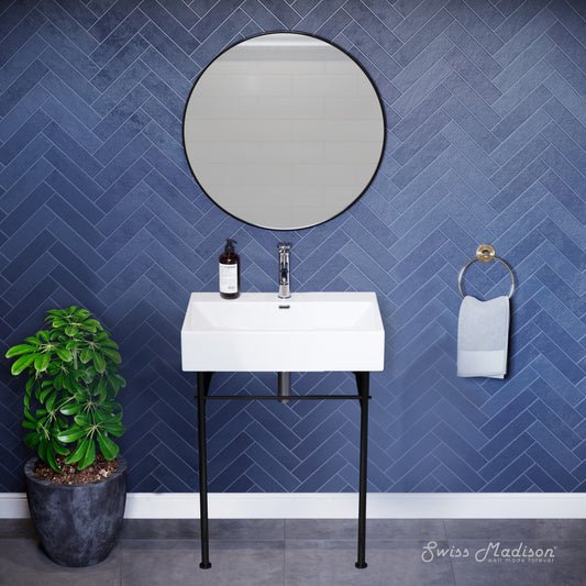 Small white console sink with black metal legs, round mirror, mounted faucet, blue herringbone tile wall.